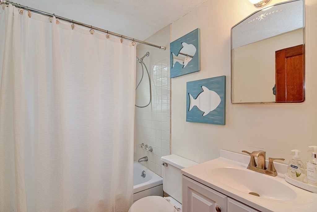 27 Naushon Road Dennis, MA 02639 - Photo 20 of 31 a bathroom with a sink mirror and a toilet