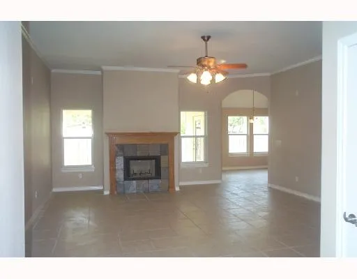 a view of a livingroom with a fireplace a chandelier and windows