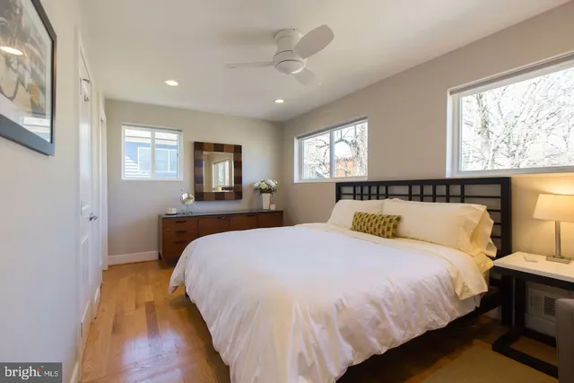 a bed sitting in a spacious bedroom next to a window