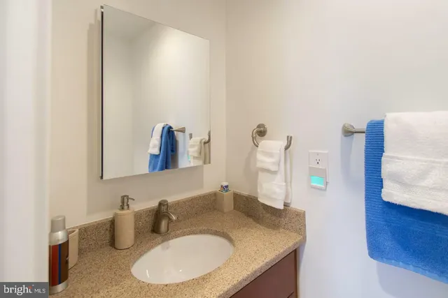 a bathroom with a granite countertop sink and a mirror