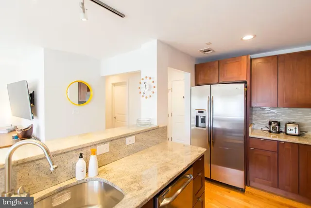 a kitchen with granite countertop a refrigerator and a sink