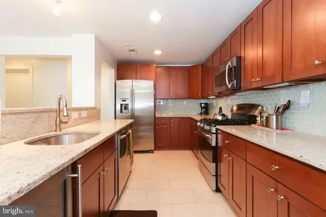a kitchen with stainless steel appliances granite countertop a sink stove and refrigerator