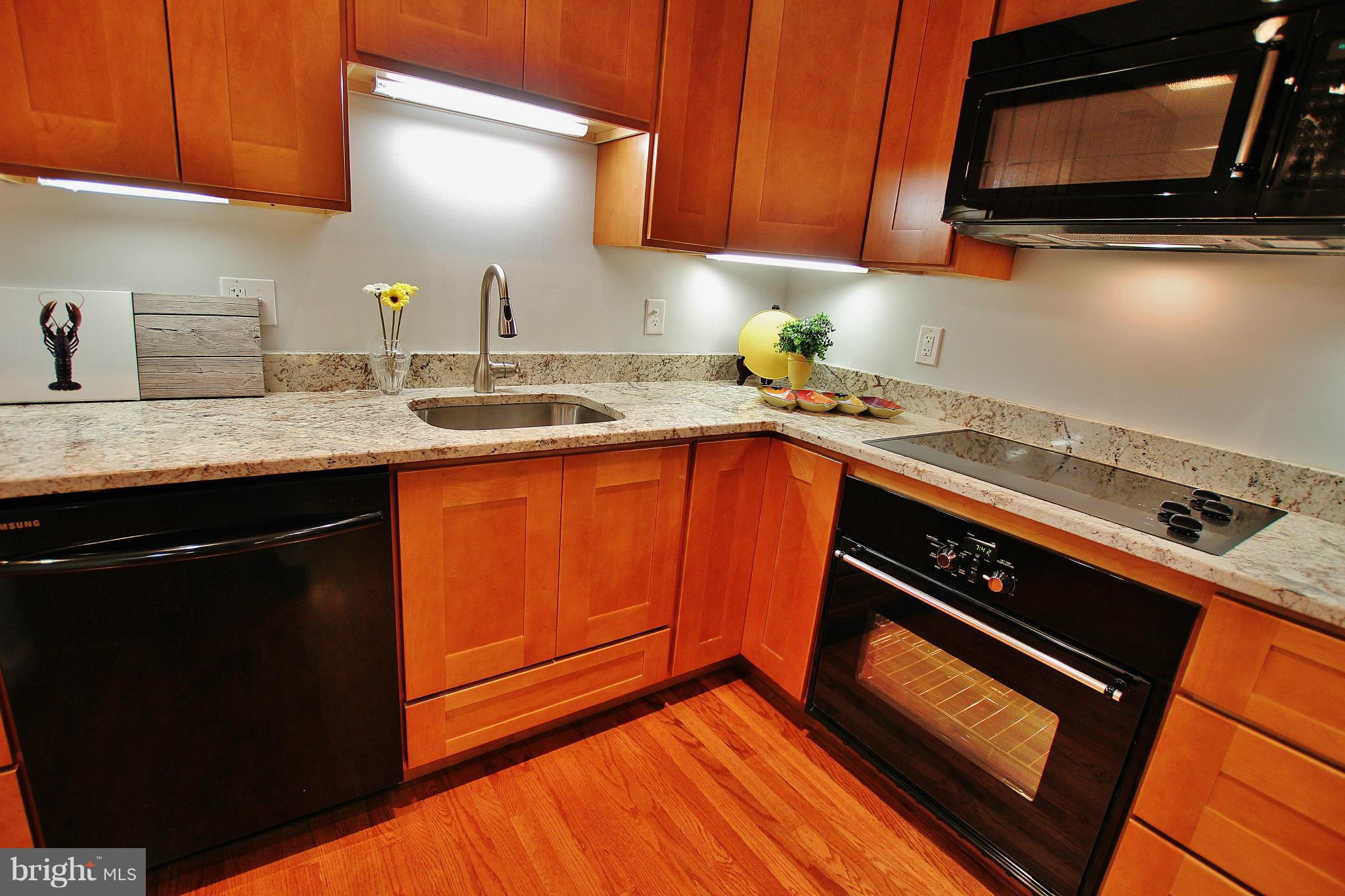 18049 Possum Point Road Dumfries, VA 22026 - Photo 11 of 30 a kitchen with granite countertop a sink stove and microwave