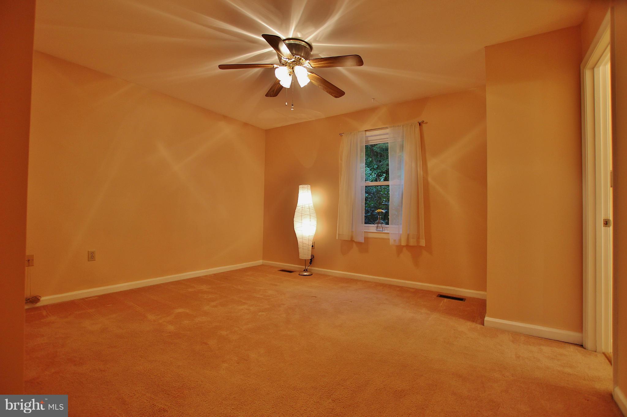 18049 Possum Point Road Dumfries, VA 22026 - Photo 17 of 30 an empty room with a chandelier fan and windows