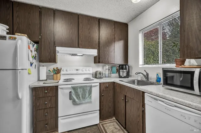 a kitchen with a refrigerator sink stove and cabinets