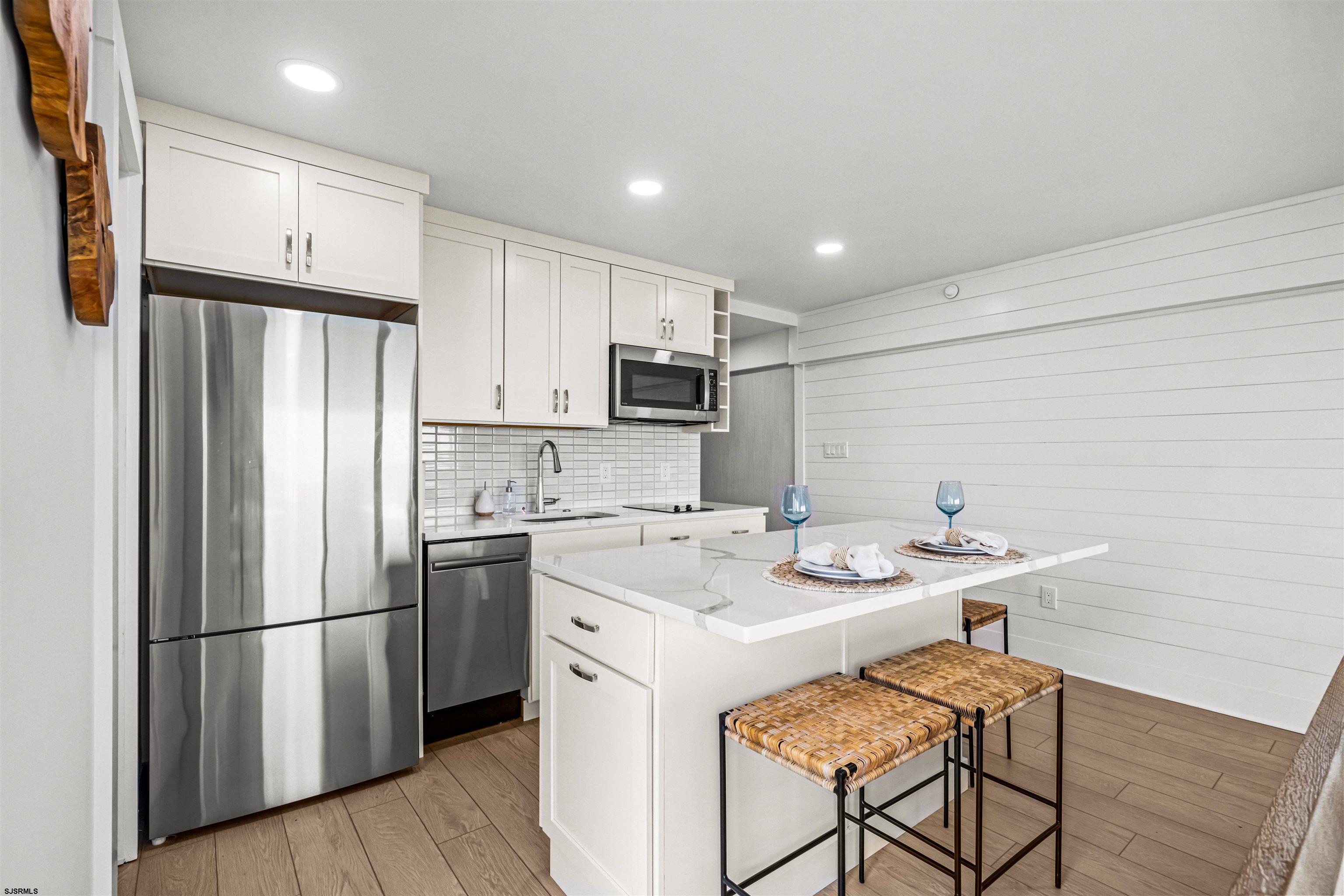 321 South 6th Street, Unit 4 Brigantine, NJ 08203 - Photo 17 of 26 a kitchen with stainless steel appliances granite countertop a refrigerator a sink a stove a microwave and island
