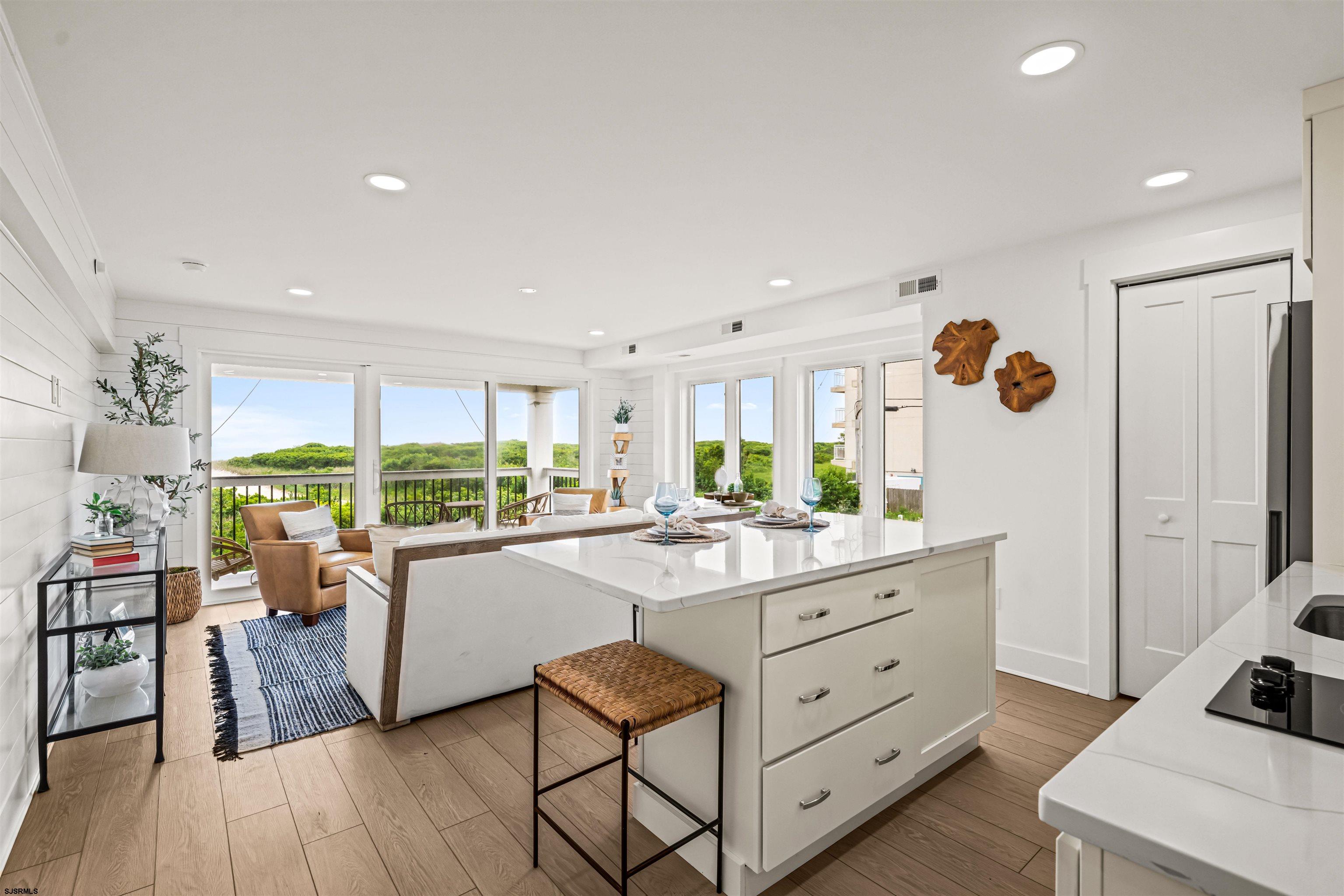321 South 6th Street, Unit 4 Brigantine, NJ 08203 - Photo 7 of 26 a kitchen with white cabinets and wooden floors