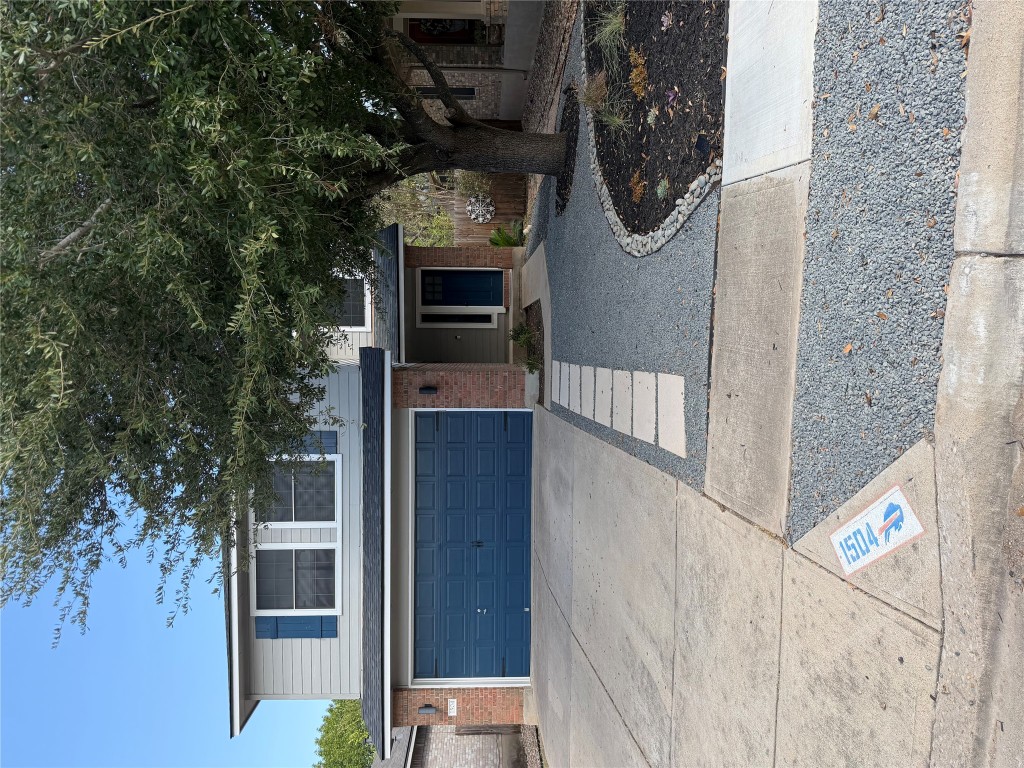 a front view of house with yard and trees in the background