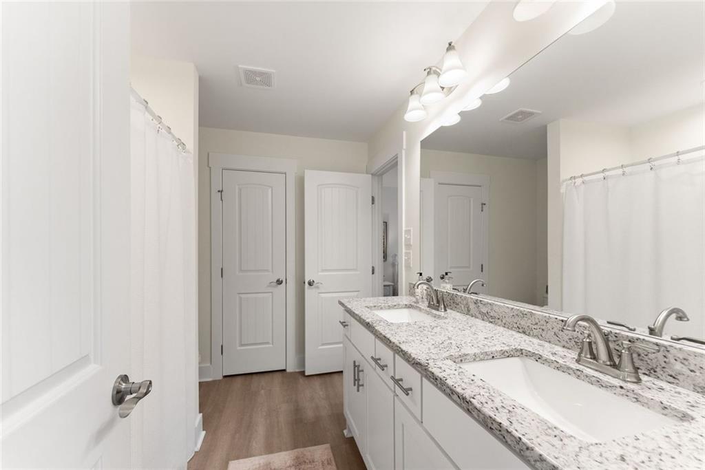 6998 Britt Gailey Road Clermont, GA 30527 - Photo 53 of 92 a bathroom with a granite countertop sink a large mirror and a bathtub