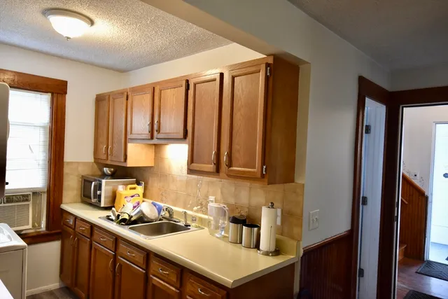 a kitchen with a sink a stove cabinets and a wooden floor