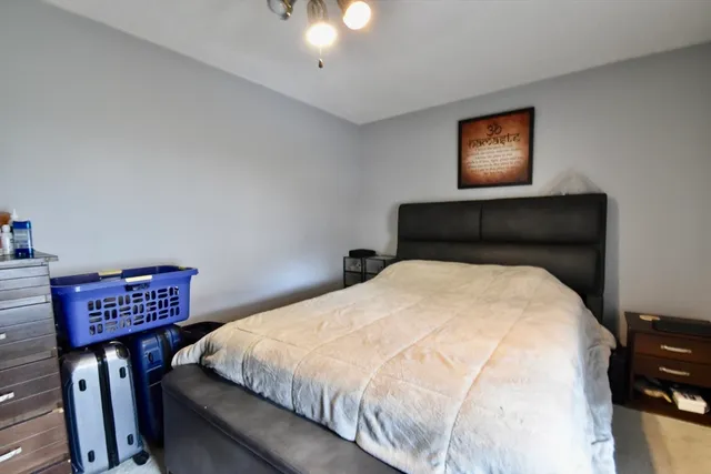 a bedroom with a bed and a painting on the wall