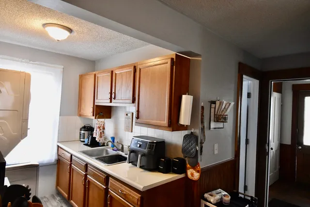 a kitchen with sink refrigerator dining table and chairs