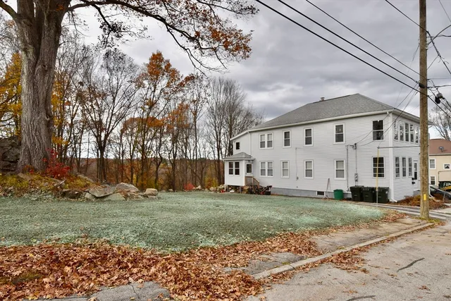 a view of a white house with a yard