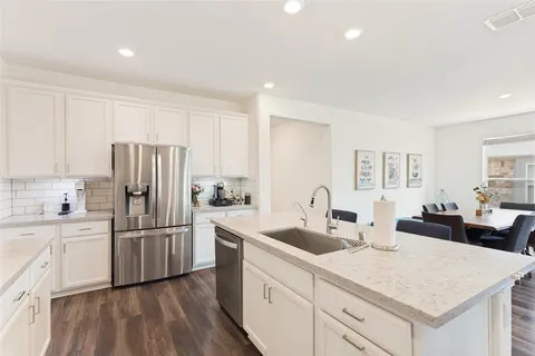 a kitchen with white cabinets and stainless steel appliances