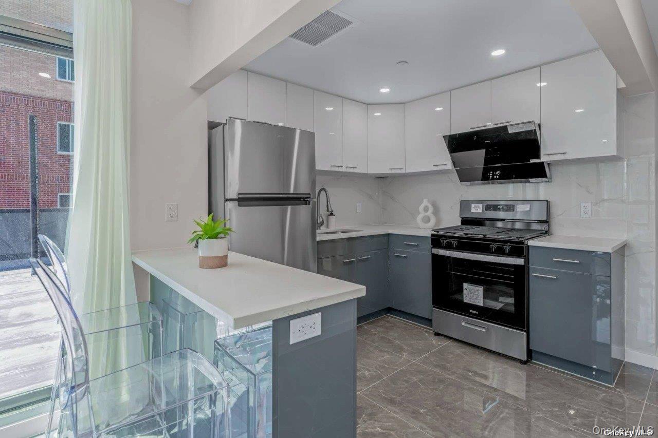 43-30 52nd Street, Unit 3B Queens, NY 11377 - Photo 12 of 14 a kitchen with stainless steel appliances a stove a sink a microwave a refrigerator a microwave and cabinets