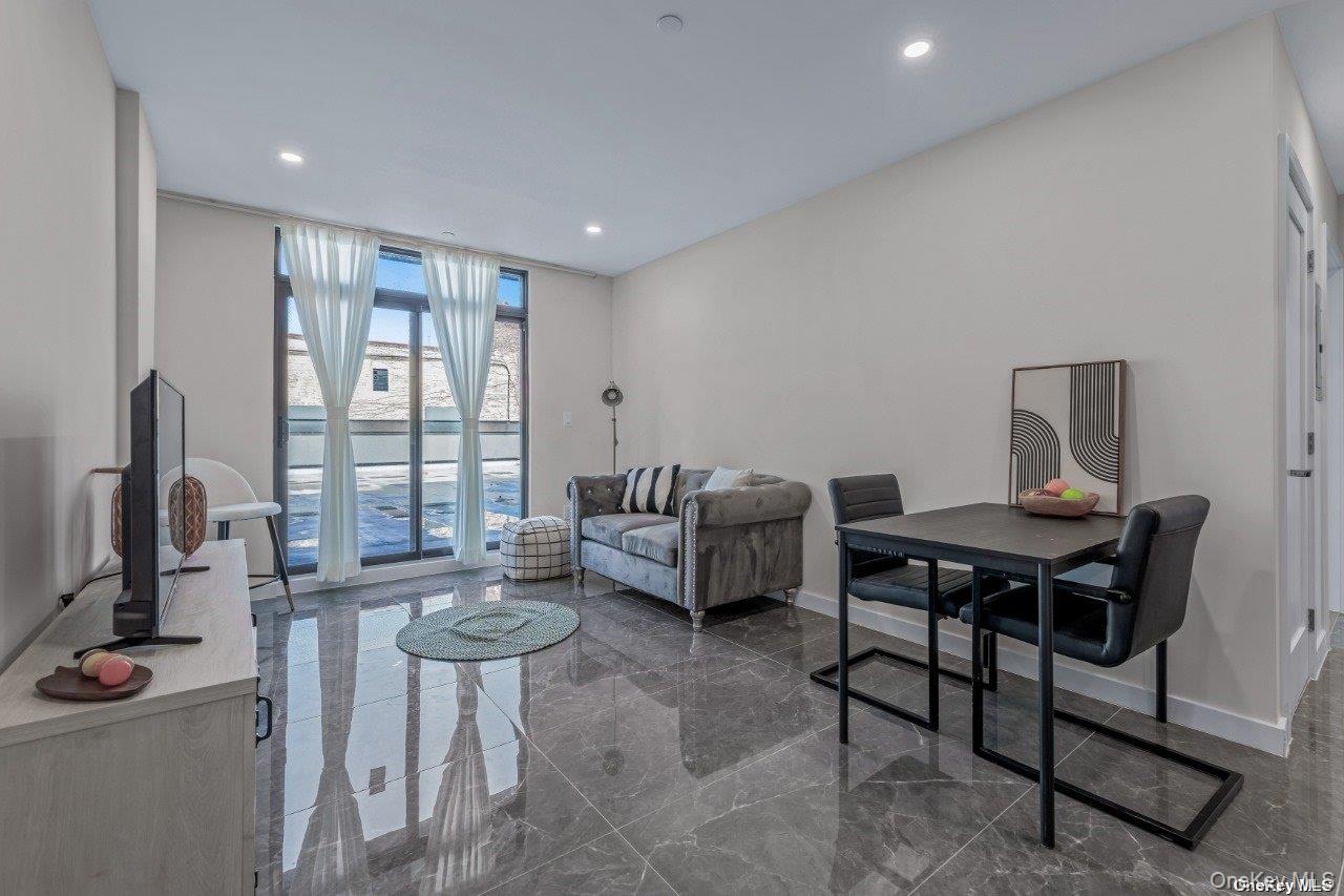 43-30 52nd Street, Unit 3B Queens, NY 11377 - Photo 7 of 14 a living room with furniture a window and a table