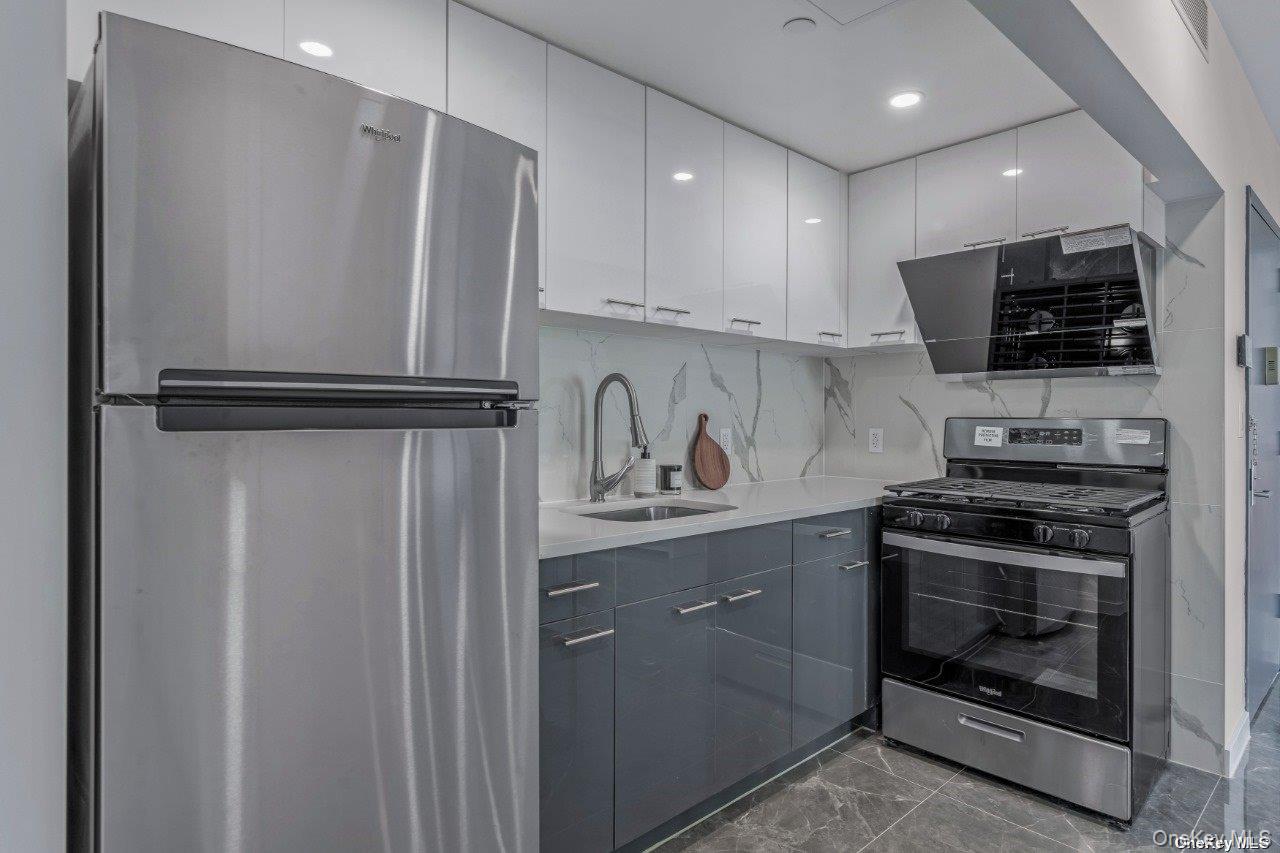 43-30 52nd Street, Unit 3B Queens, NY 11377 - Photo 8 of 14 a kitchen with stainless steel appliances a refrigerator sink and microwave
