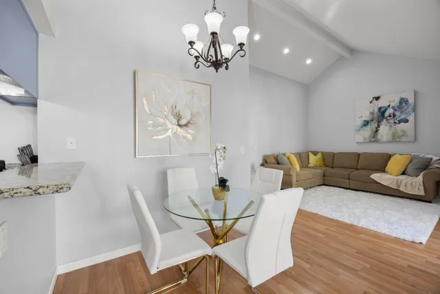 a view of a dining room with furniture a chandelier and wooden floor