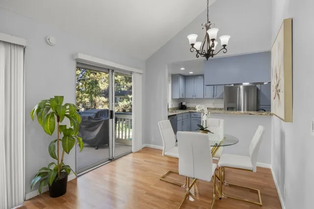 a view of a dining room with furniture a livingroom and chandelier