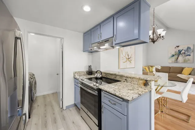 a kitchen with stainless steel appliances granite countertop a stove a refrigerator and a wooden cabinets