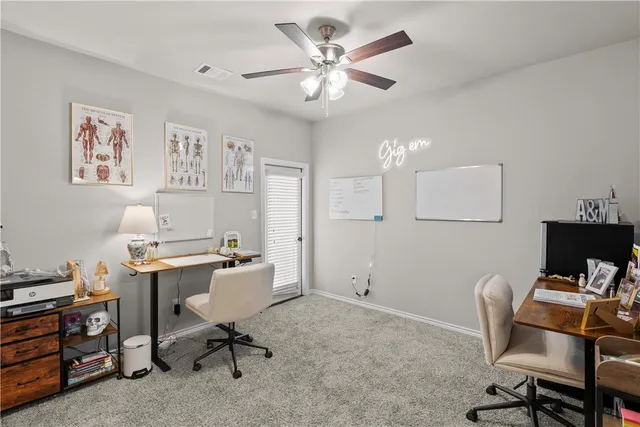 a view of a workspace with furniture and a window