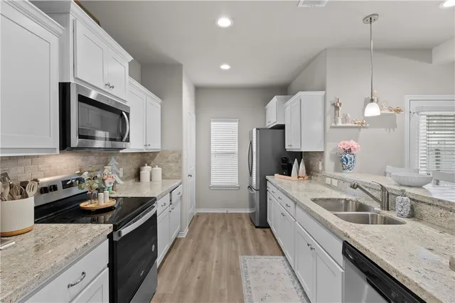 a kitchen with a sink stove top oven and refrigerator