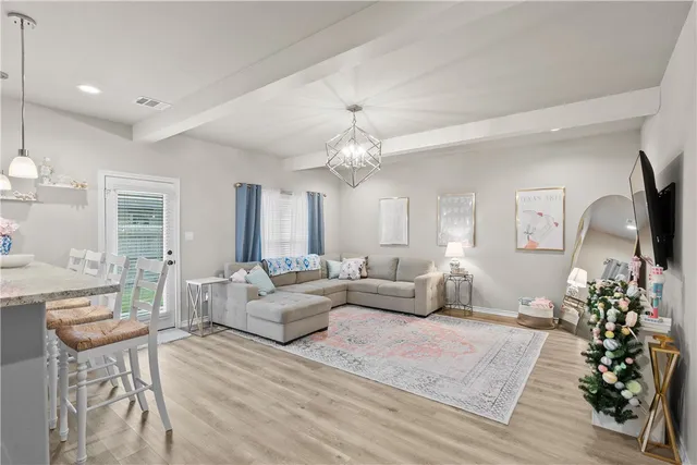 a living room with furniture or chandelier and a wooden floor