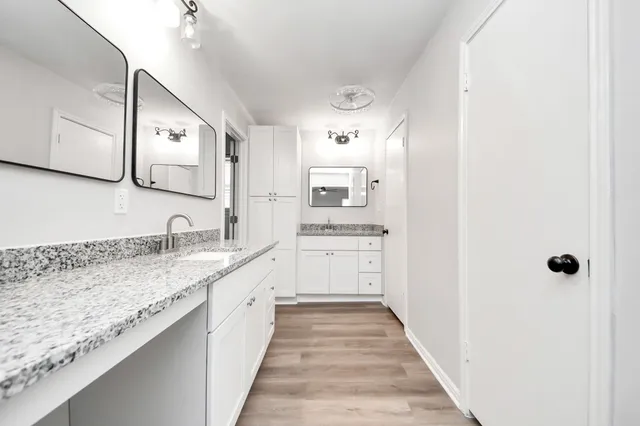 a bathroom with a granite countertop sink and a mirror