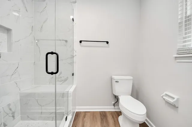 a bathroom with a toilet and a shower