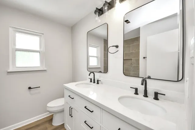 a bathroom with a toilet sink and mirror