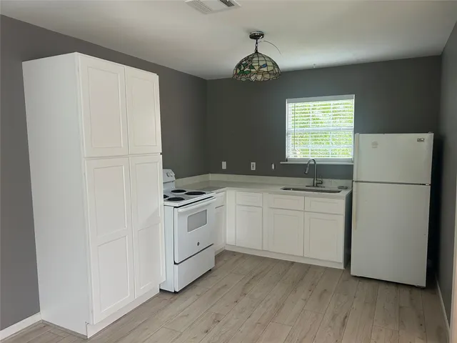 a kitchen with a refrigerator sink and cabinets