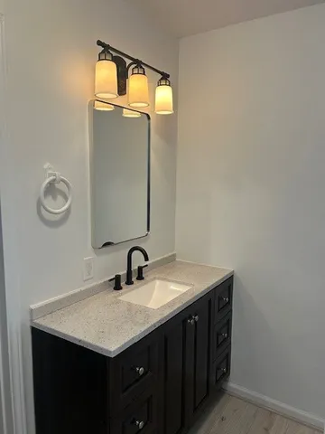 a bathroom with a sink vanity and a mirror