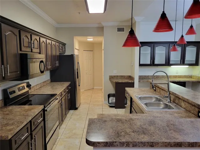 a kitchen with stainless steel appliances granite countertop a sink wooden cabinets and a stove