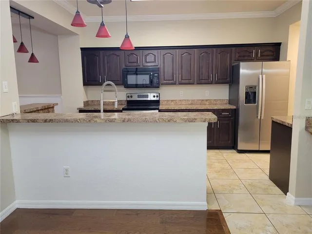 a kitchen with stainless steel appliances granite countertop a refrigerator and a stove top oven