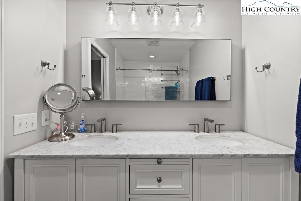 1157 Pine Ridge Road Beech Mountain, NC 28604 - Photo 19 of 41 a bathroom with a granite countertop sink a mirror and vanity