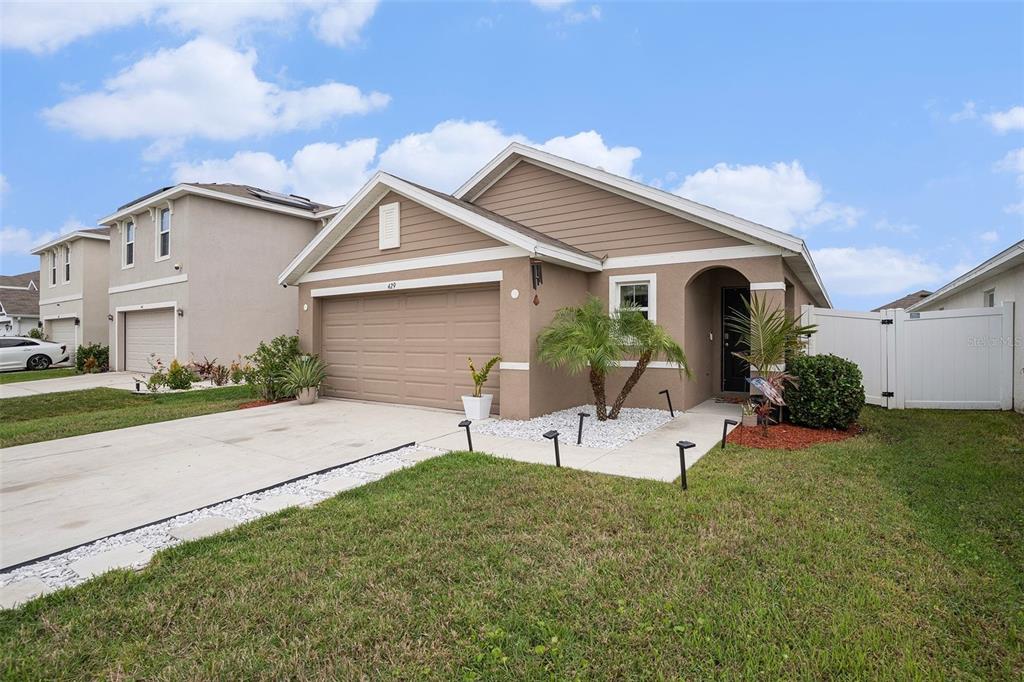 429 Olive Conch Street Ruskin, FL 33570 - Photo 2 of 15 a view of a white house next to a yard with potted plants