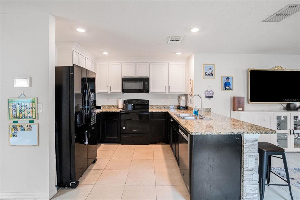 429 Olive Conch Street Ruskin, FL 33570 - Photo 7 of 15 a kitchen with stainless steel appliances kitchen island granite countertop a refrigerator and a stove top oven