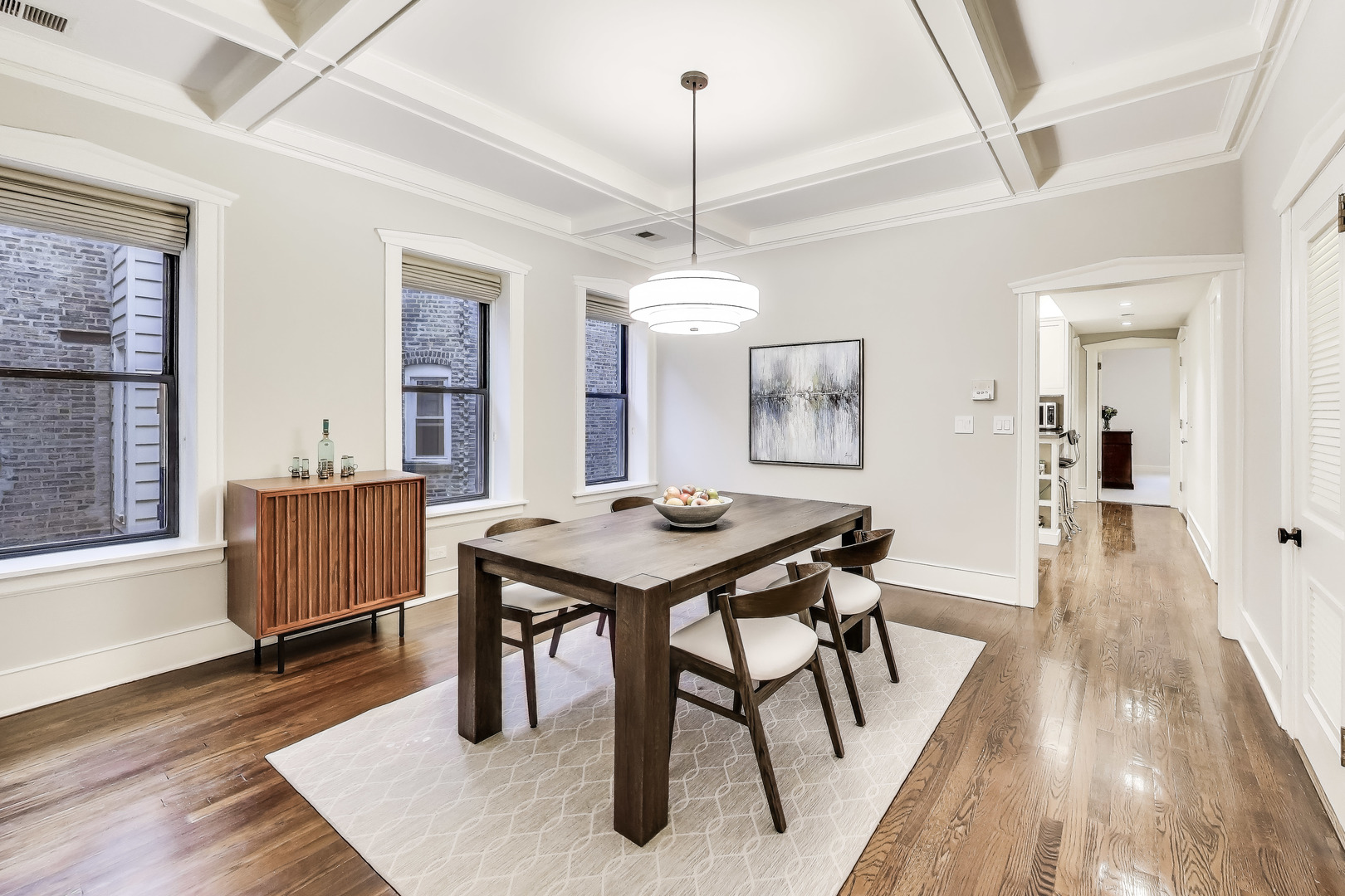 628 West Grace Street, Unit 2W Chicago, IL 60613 - Photo 11 of 32 a dining room with wooden floor a chandelier a wooden table and chairs