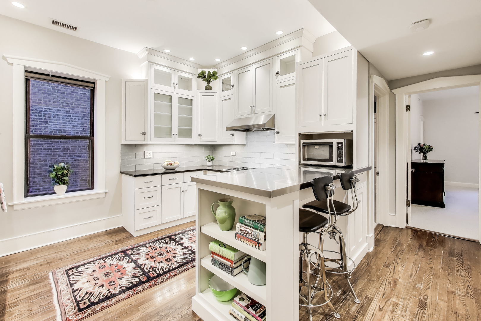 628 West Grace Street, Unit 2W Chicago, IL 60613 - Photo 14 of 32 a kitchen with stainless steel appliances kitchen island granite countertop a refrigerator and a stove top oven