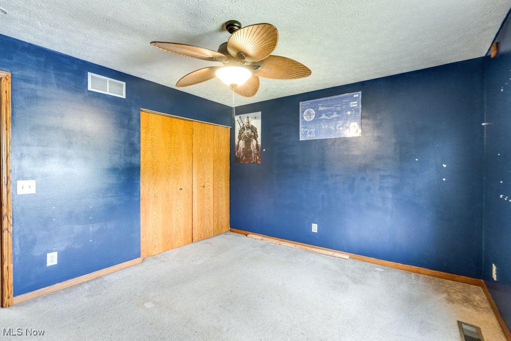 3362 Sunnybrook Road Kent, OH 44240 - Photo 30 of 50 Unfurnished bedroom with a textured ceiling, carpet floors, a closet, and a ceiling fan