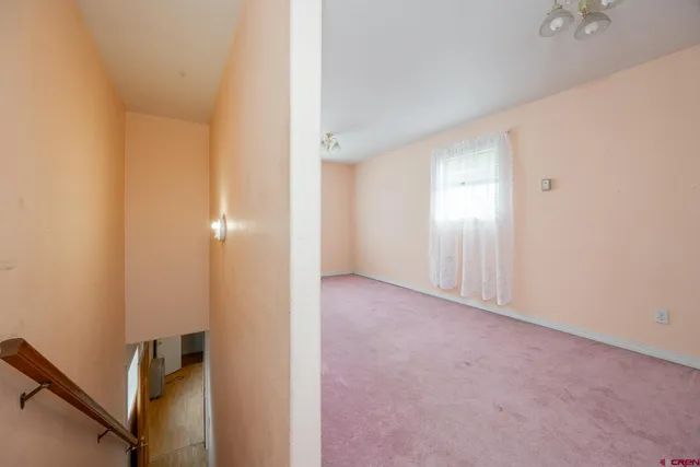 a view of an empty room with a fireplace and a window