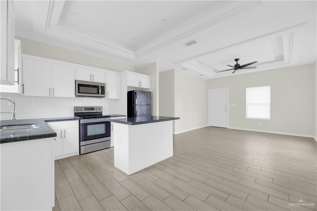 409 Rafael Drive San Juan, TX 78589 - Photo 9 of 20 a kitchen with granite countertop white cabinets and stainless steel appliances