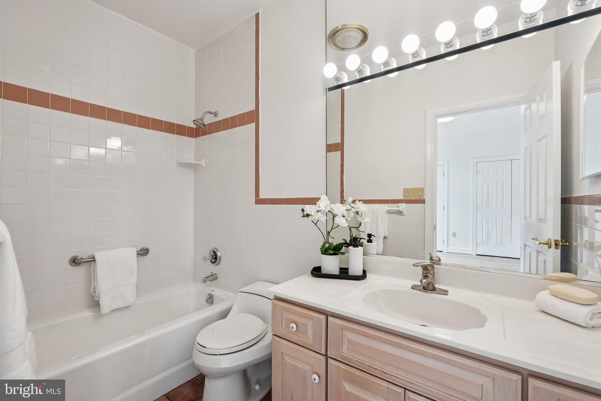 9309 Bells Mill Road Potomac, MD 20854 - Photo 18 of 38 a bathroom with a sink a toilet and a mirror