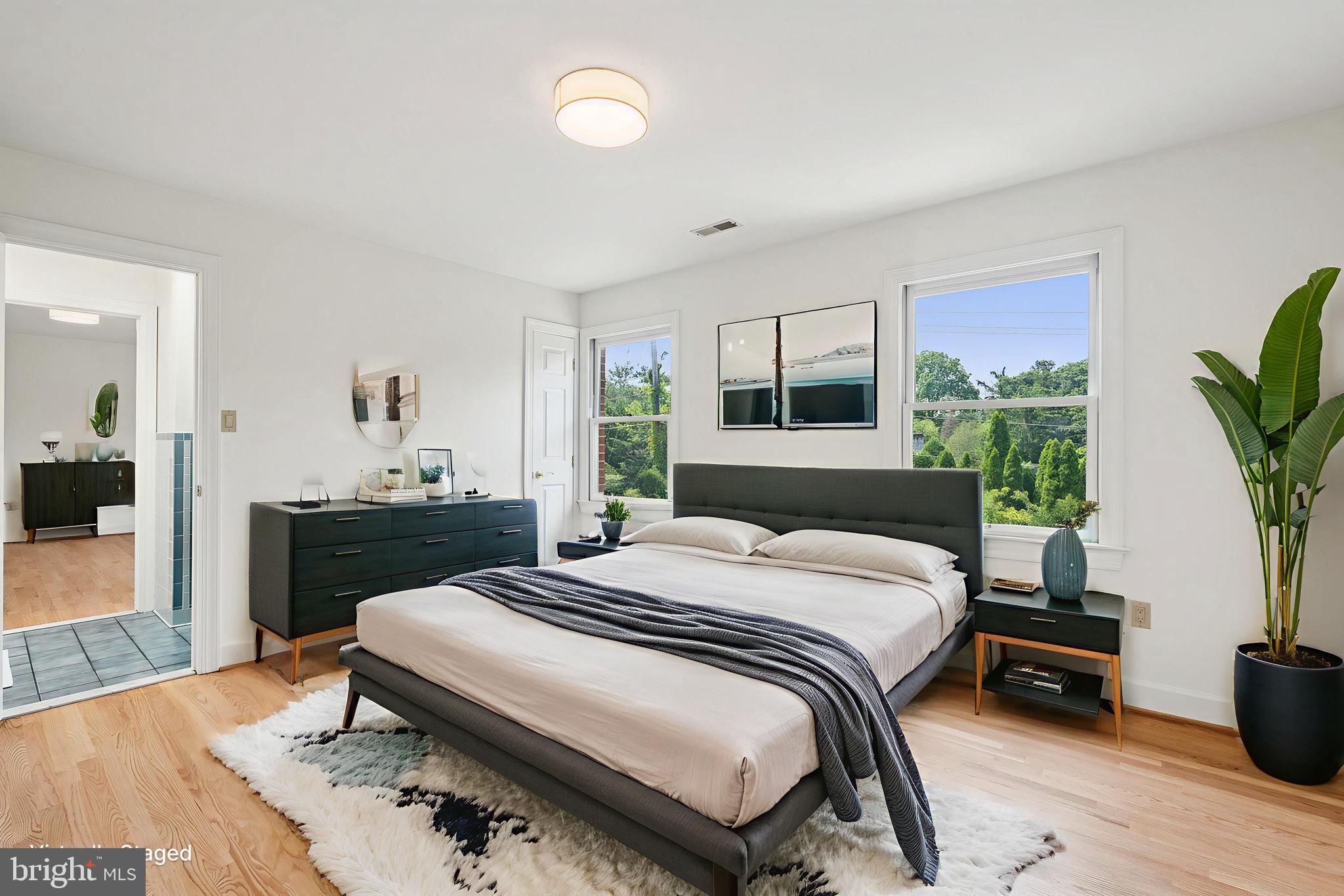 9309 Bells Mill Road Potomac, MD 20854 - Photo 27 of 38 a bedroom with a bed and a potted plant on the dresser