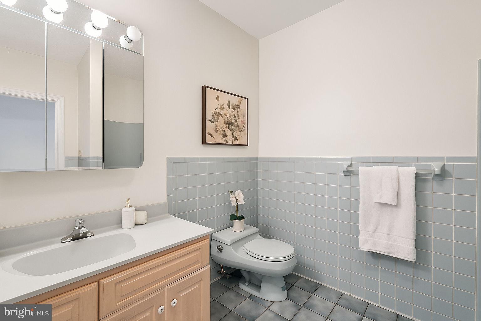 9309 Bells Mill Road Potomac, MD 20854 - Photo 32 of 38 a bathroom with a toilet sink vanity and mirror