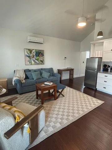 a living room with stainless steel appliances kitchen island granite countertop a couch and a view of living room