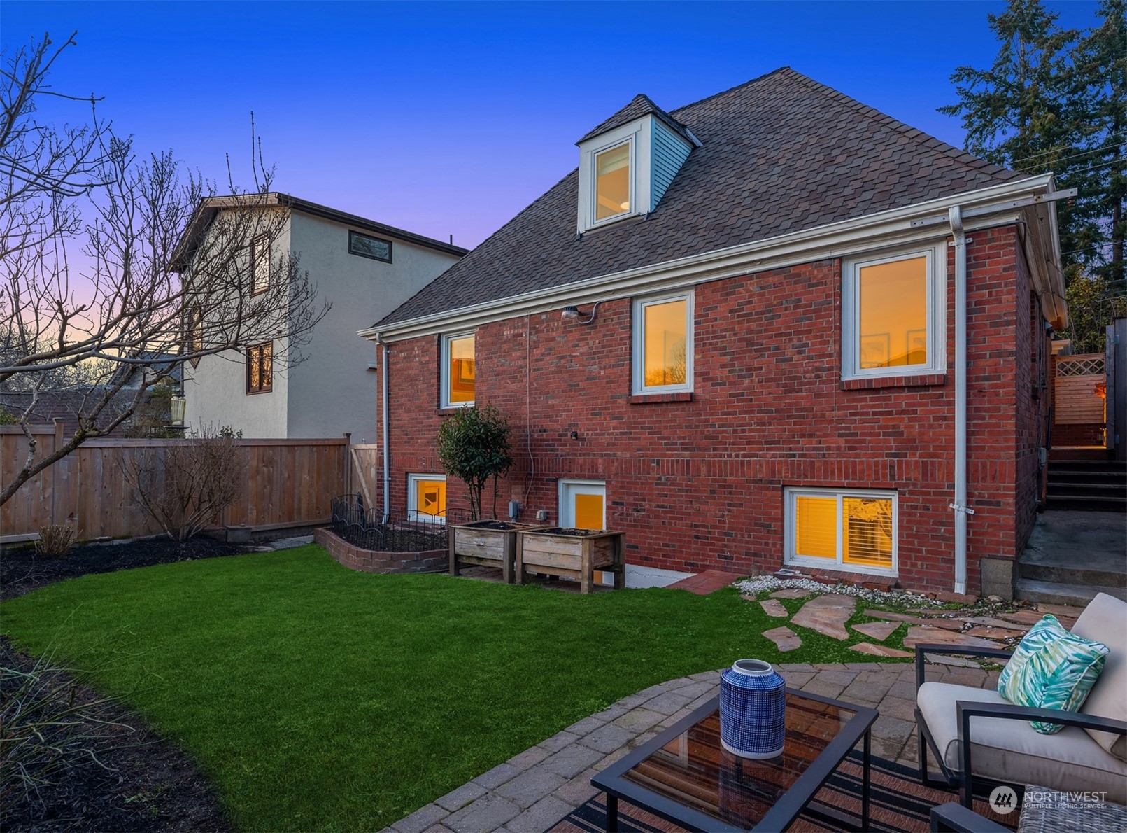 4335 Northeast 45th Street Seattle, WA 98105 - Photo 32 of 37 a view of a brick house with a yard chairs and a table