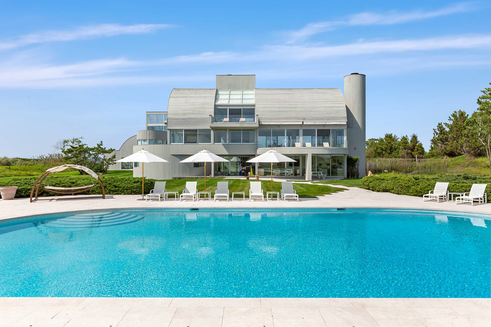 Undisclosed Address Southampton, NY 11968 - Photo 35 of 43 a view of a swimming pool with lawn chairs and a big yard