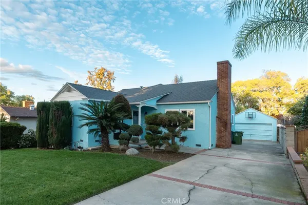 front view of house with a yard and potted plants