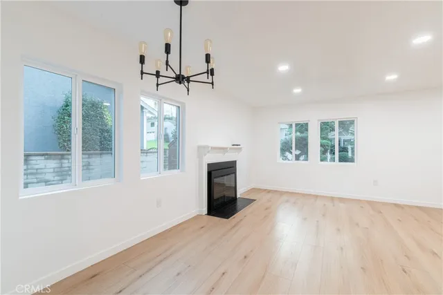 a view of an empty room with a window and fireplace